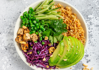 Asia Reis Bowl mit Tofu, Rotkohl, Avocado, Gurke und Koriander 