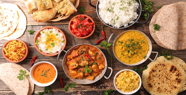Verschiedene Gerichte mit dem Curry Gewürz auf einem Tisch angerichtet 